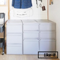 like-it 可堆疊抽屜式收納箱，展示於附有掛架的牆壁下方，箱體為淺灰色。