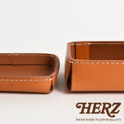 兩個棕色皮革製成的手工收納盒，帶有縫線細節，其中一個展示了內部空間。