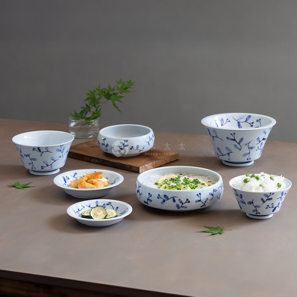 波佐見燒藍花紋六件式碗盤組，包含不同尺寸的白色陶瓷碗盤，皆飾有藍色植物花紋，其中有兩碗盛有日式料理。