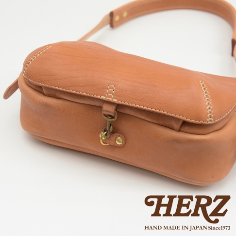 職人手作皮革大容量扣環郵差包，焦糖棕色，採用柔軟皮革製成，搭配復古金屬扣環和車縫線設計。