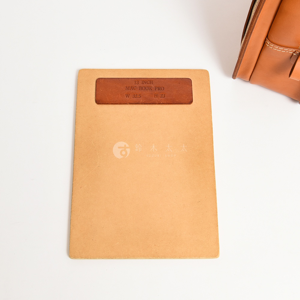 淺棕色皮革內襯板，印有「13 INCH MAC BOOK PRO W 32.5 H 23」，下方有「鈴木太太」的商標。