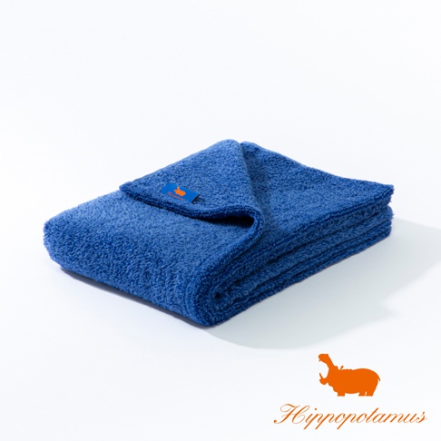 一張藍色竹棉混紡大浴巾，表面呈現柔軟的紋理，疊放在白色背景上，浴巾上帶有橘色標籤。