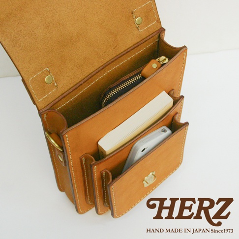 職人手作皮革單肩兩用小方包，天然棕色皮革，設計簡約，內部可放置手機、書本與零錢包，金屬釦與車縫線細緻，展現質感。