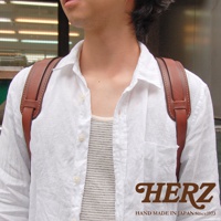 職人手作皮革Big肩墊，棕色皮革，搭配白色襯衫，展示產品的細節與質感。