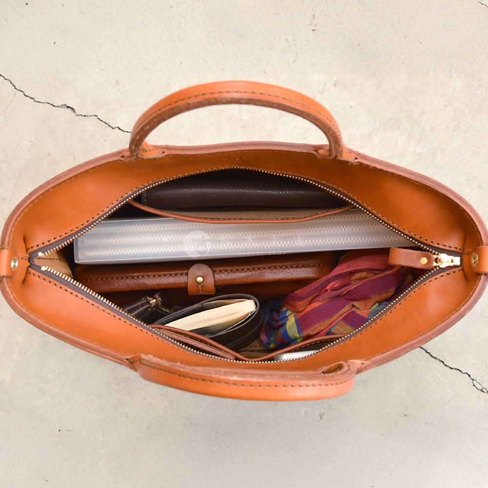 HERZ G-45 兩用拉鍊托特包，精緻的職人手作皮革，內部空間寬敞，可放入筆記本、文件夾和絲巾等物品，展現實用與時尚。