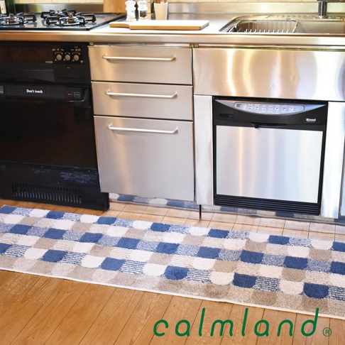 北歐風地墊，採用藍色、米白色與淺褐色交織的菱格紋與半圓塊圖案，材質觸感柔軟，尺寸適合廚房或居家空間。