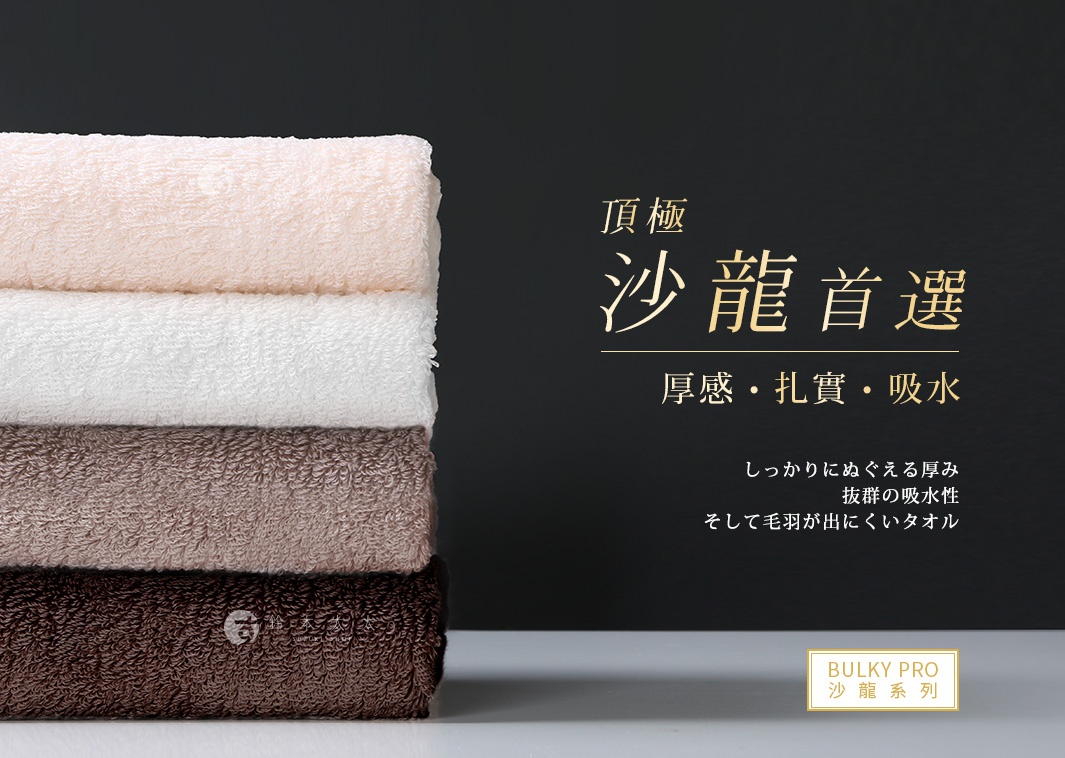 堆疊的四條今治沙龍浴巾，顏色由上至下分別為淺粉色、白色、淺棕色和深棕色，材質皆為柔軟的毛圈布。