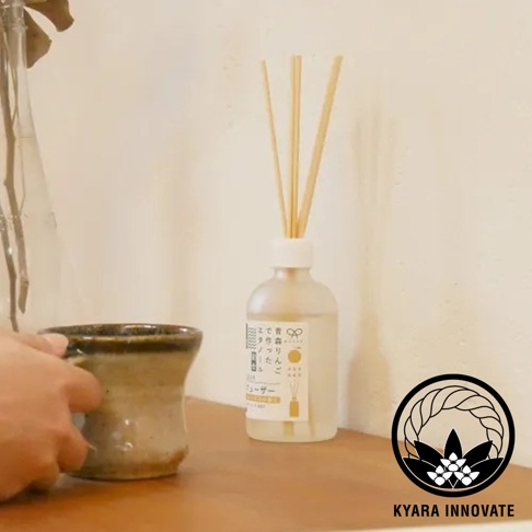 一只手拿起陶杯，旁邊有個擴香瓶，瓶身貼有日文標籤，右下角有標誌和文字 KYARA INNOVATE
