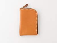 棕色皮革迷你錢包，帶有拉鍊和皮革拉環，縫線整齊，邊緣圓潤。