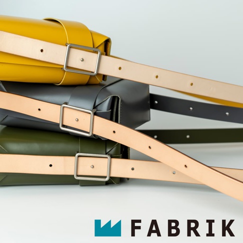 FABRIK 品牌 logo 和文字，搭配堆疊的黃色、灰色和綠色皮革斜背包，展現皮革背帶和金屬扣環細節