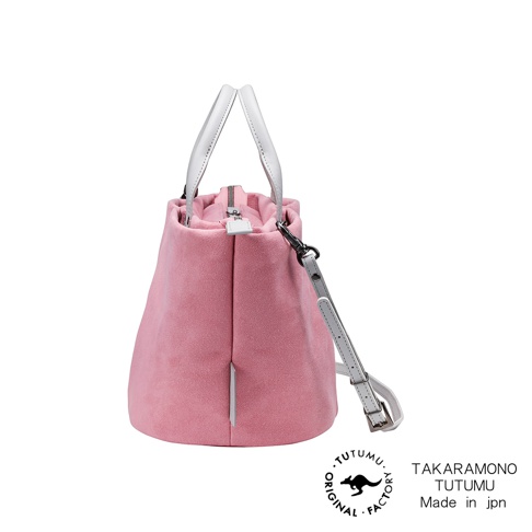 TUTUMU 品牌粉紅色絨面皮革托特包，配有白色皮革手柄和可拆卸斜挎帶，包包上印有 TUTUMU 和 TAKARAMONO TUTUMU Made in jpn 字樣。