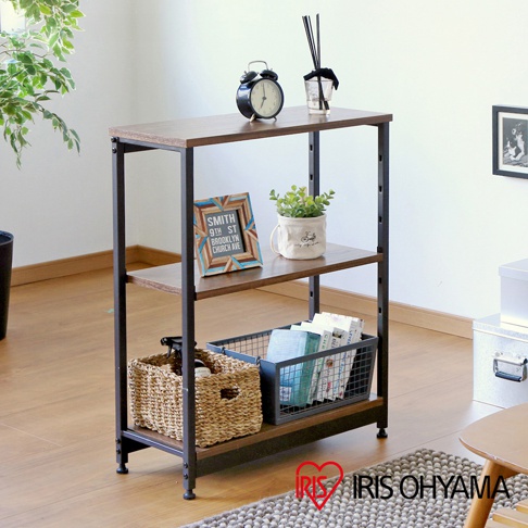 鐵木層架，三層寬型設計，木紋層板搭配黑色金屬框架，層架上擺放時鐘、植栽、相框、編織籃及書籍。