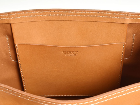 職人手作皮革原子釦托特包 (T-43)，內部特寫，呈現天然棕色皮革材質，內有縫線分隔的置物袋，品牌標誌壓印於袋面。