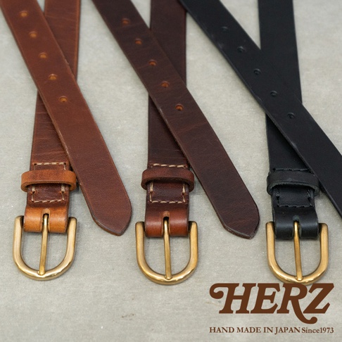 日本HERZ職人手作皮革Organ英倫皮帶，展示三色（棕色、深棕色、黑色）皮帶，搭配黃銅色實心D型皮帶環，下方印有HERZ品牌標誌與HAND MADE IN JAPAN Since1973字樣。