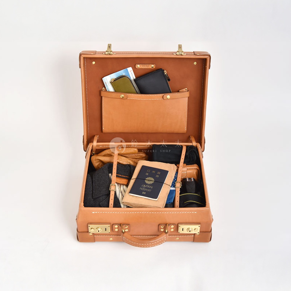 職人手作皮革英倫風便攜手提行李箱 TR-1，棕褐色皮革材質，箱內裝有衣物、手套、錢包、護照及其他小物，箱蓋內有兩個皮製夾層，箱外有金屬鎖扣及提把。