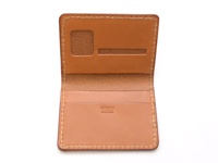 職人手作皮革雙折證件收納夾 (KC-43)，淺棕色全皮革製，內有兩個證件插槽，其中一個帶有透明視窗，另一條插槽較窄，適合放置卡片。皮革表面光滑，邊緣以米白色縫線手工縫製。