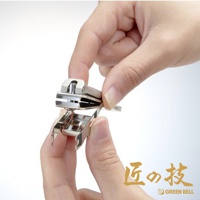 一雙手正操作著銀色金屬材質的指甲剪，指甲剪有集屑設計，細節處呈現鍛造質感。