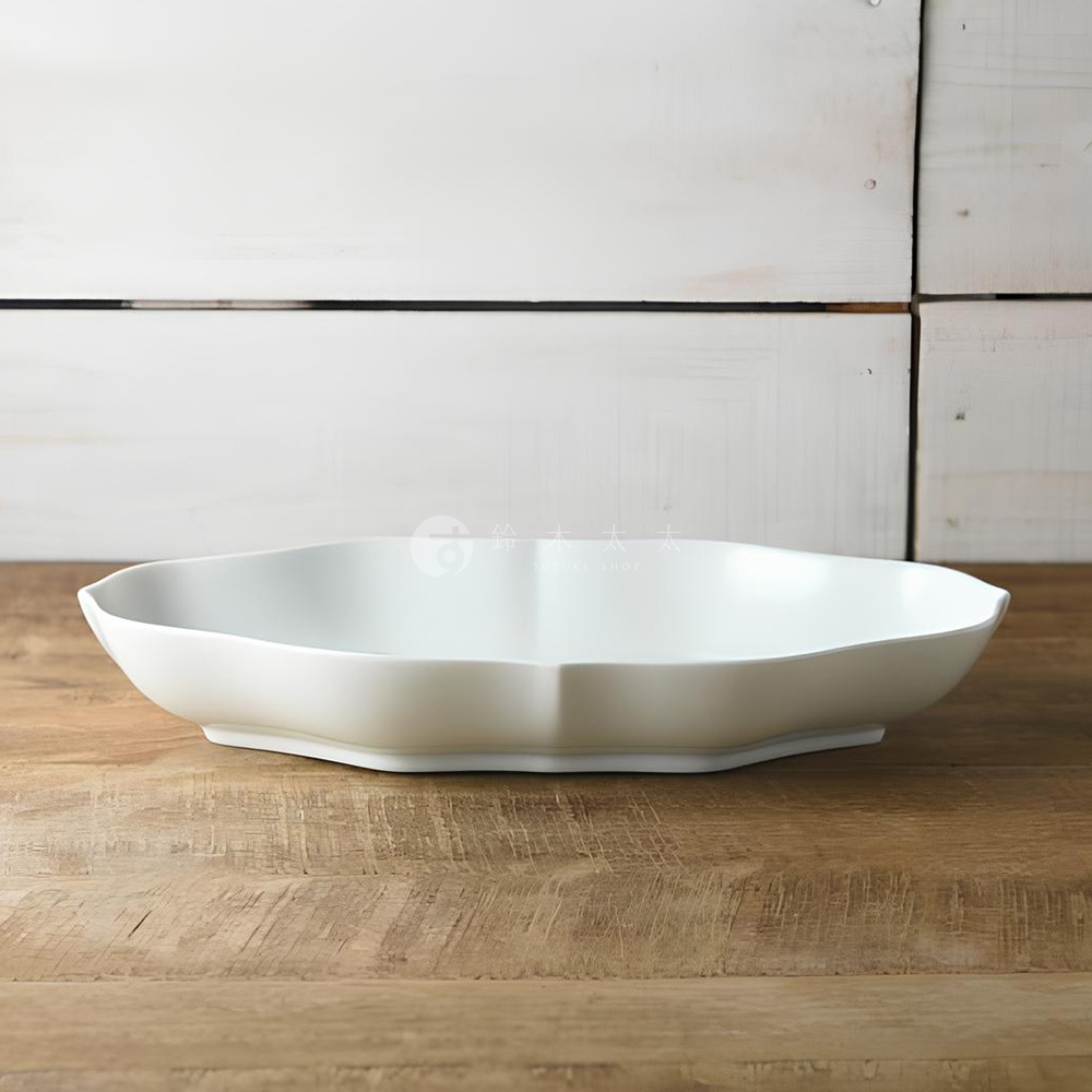 Tsudoi 淡青白釉美濃燒輪花長盤，呈現柔和的淡青白色澤，輪狀花瓣造型，材質為陶瓷，整體呈橢圓長盤狀，置於木紋背景上。