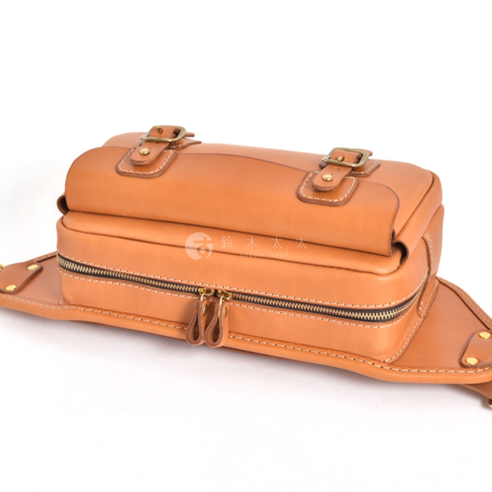 職人手作皮革騎士隨身斜背包，淺棕色，帶有雙拉鍊主袋、兩個金屬扣環裝飾的翻蓋，以及可調節的皮革背帶。