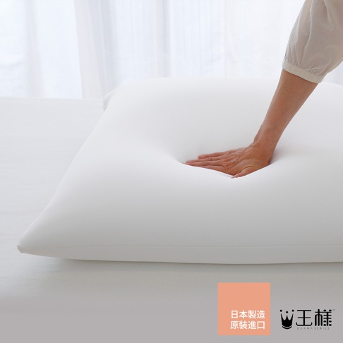 白色雙面BIG夢枕，材質柔軟，手部按壓呈現明顯凹陷。