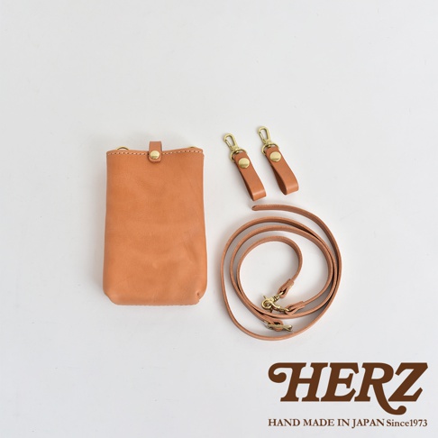 職人手作皮革手機包，淺棕色，附有可拆卸的皮質背帶及兩個皮質掛環，全為真皮材質。