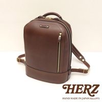 職人手作立體棕色皮革商務後背包，設有金色拉鍊和品牌標誌，皮革質感厚實，設計簡約大方。