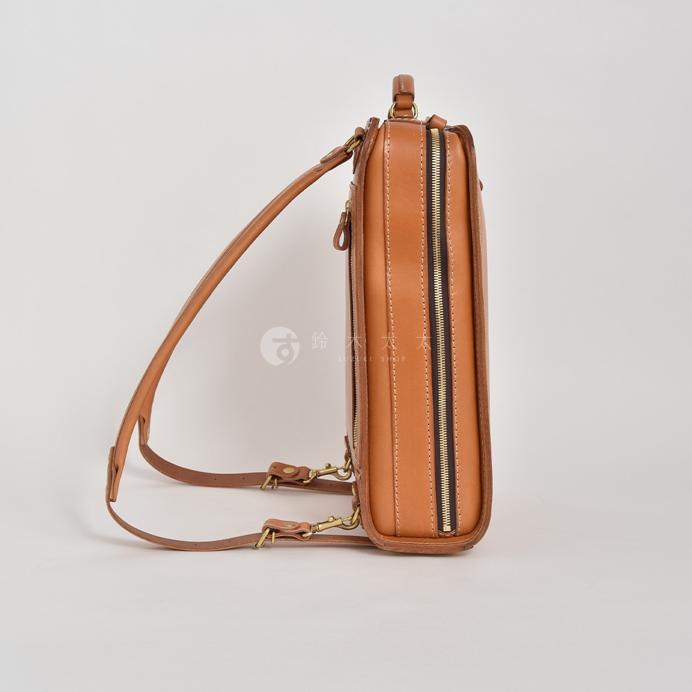 職人手作皮革商務電腦後背包 R-25，經典棕色，採用頭層牛皮製成，搭配金色拉鍊和金屬扣環，展現簡約俐落的設計風格。