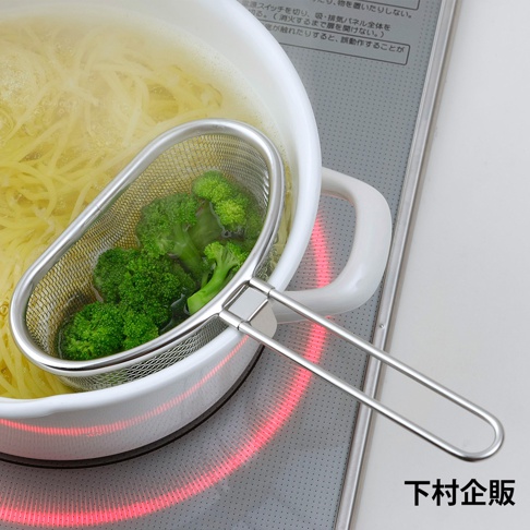 不鏽鋼長柄濾網，網孔細密，內含水煮中的綠色花椰菜，置於白色鍋中，鍋內有黃色麵條。