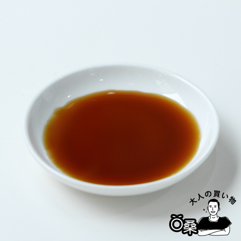 白色碗中盛有琥珀色液體，為森文柑橘醋調味料。