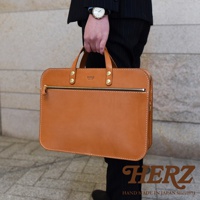 職人手作皮革兩用商務公事包，採用棕色皮革，搭配金色拉鍊和鉚釘，設計簡潔大方。