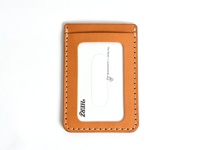 一個直式、淺棕色皮革票券收納夾，配有縫線和透明視窗，上面印有品牌標誌「HERZ」和英文文字。