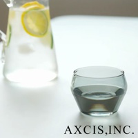 LAGOM清透復古玻璃杯，S尺寸，圓潤造型，灰色調，杯中裝有約一半的水。背景為玻璃水壺，內有檸檬片和冰塊。