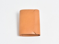 淺棕色皮革製成的 A6 記事本書套，呈現簡潔的設計，邊緣有縫線裝飾。