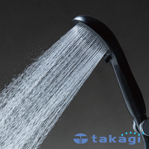 一支黑色的 takagi 品牌手持式蓮蓬頭，正向下方噴灑出綿密且充滿動感的細緻水柱，背景為深灰色調，呈現出洗鍊簡約的現代風格。