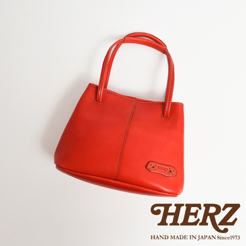 日本HERZ紅色皮革兩用托特包，上面有HERZ的壓印標誌，整體為簡約設計。