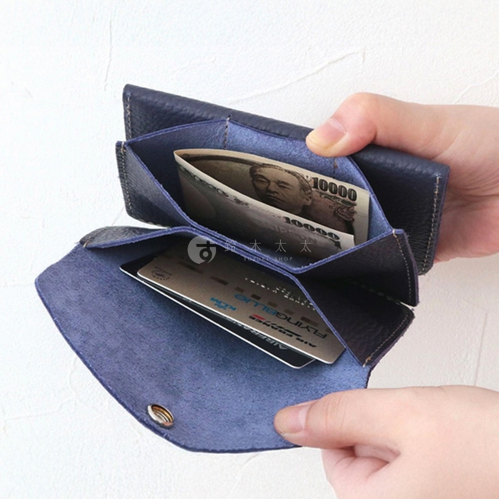 深藍色皮革零錢包，內有日幣鈔票與信用卡。