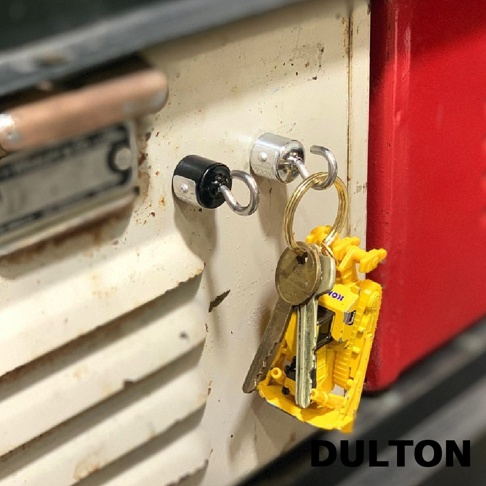 DULTON 標誌旁，一串鑰匙掛在鑰匙圈上，其中一個鑰匙圈上還掛著一個黃色的工程車玩具。