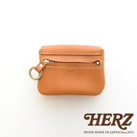 職人手作皮革旅行用雙層錢包，採用天然皮革材質，顏色為溫暖的棕褐色。錢包設有雙層設計，一個拉鍊開合，配有黃銅色金屬拉鍊和掛環，並壓印有「HERZ」品牌標誌。