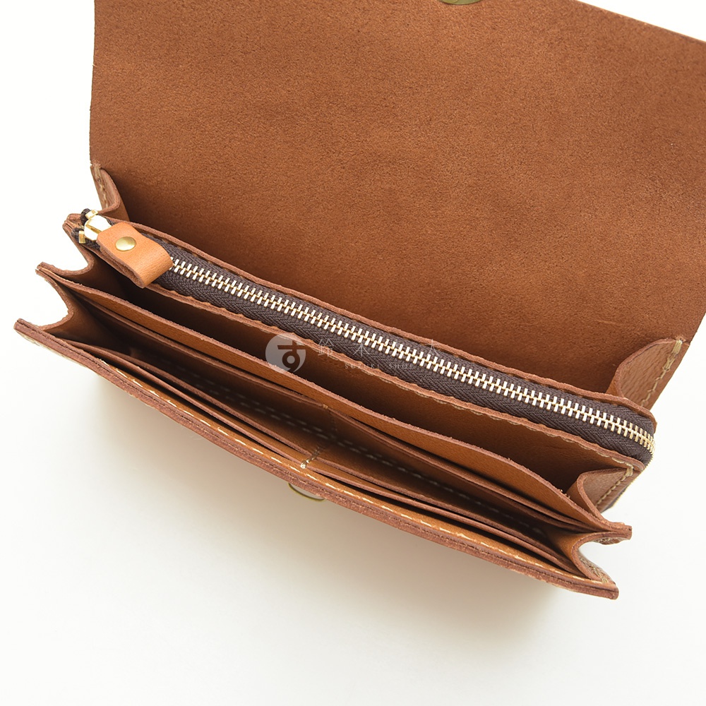 職人手作皮革長夾，展示內部多卡層與拉鍊設計，皮革顏色為棕色調，質感自然。