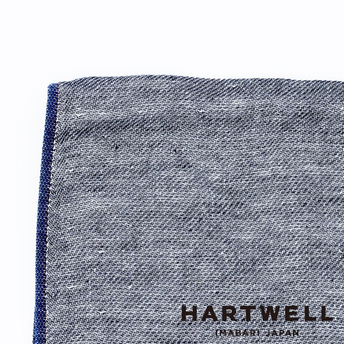 今治復古丹寧風雙織柔感毛巾，以深藍色與白色交織的細緻織紋呈現，左側邊緣有明顯的深藍色滾邊，質感柔順。