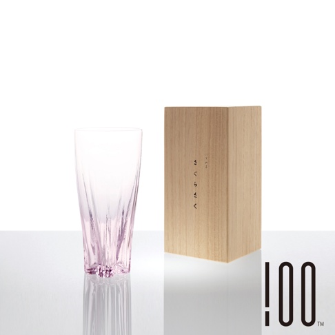 粉色玻璃啤酒杯，杯身帶有垂直紋路，底部有放射狀切割，旁邊放置木盒，盒面有日文「さくらさく」字樣。