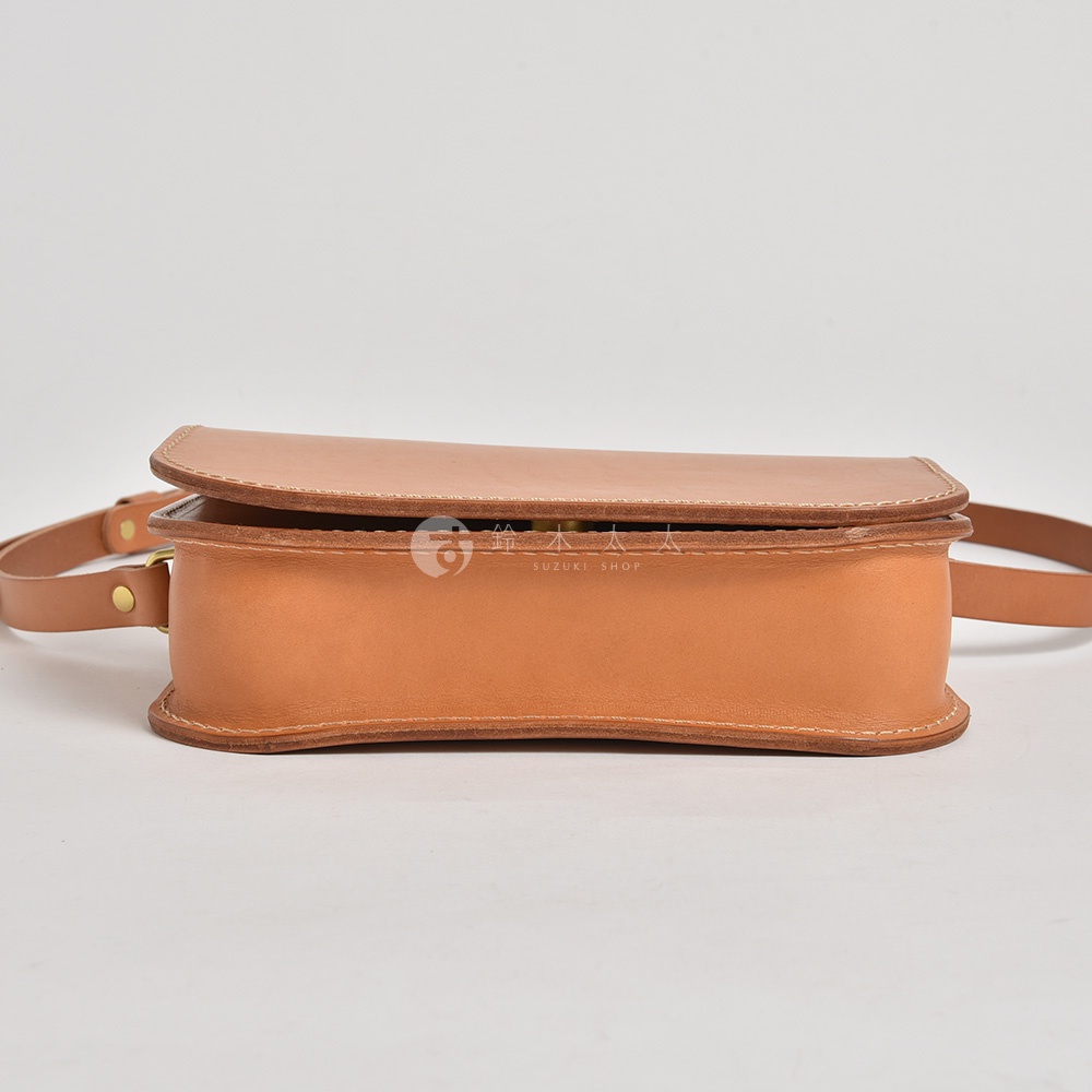 職人手作皮革翻蓋橫式單肩包，淺棕色，採用真皮材質，側面可見精細縫線及皮帶扣。