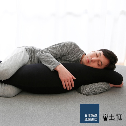 一名男子側臥，抱著一個長條形黑色抱枕，抱枕材質柔軟，呈流線型，能貼合身體曲線。