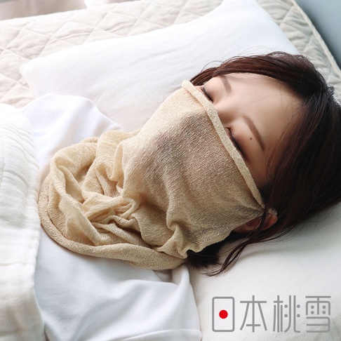 一名女性側臥在枕頭上，臉部下半部配戴著日本桃雪品牌米色透氣絲綢材質的睡眠半面罩，面罩柔軟垂墜且呈現自然皺褶，展現舒適的居家睡眠氛圍。