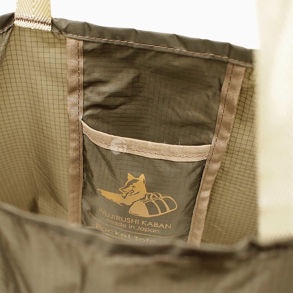 犬印鞄環保折疊收納購物袋，採用軍綠色格紋尼龍材質，設有同色系尼龍布內袋，內袋印有品牌標誌及「Pocket Tote」字樣，搭配米白色織帶提把。