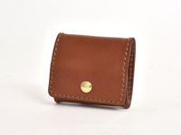 棕色皮革製作的箱型零錢包，帶有金色金屬按鈕，邊緣以米色縫線手工縫製。