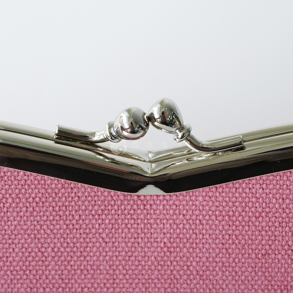 粉紅色布料質感側邊特寫，展現金屬壓扣與品牌標誌。