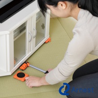 橘色圓形迷你家具起重器，配有銀色金屬提把，用於移動白色電視櫃。