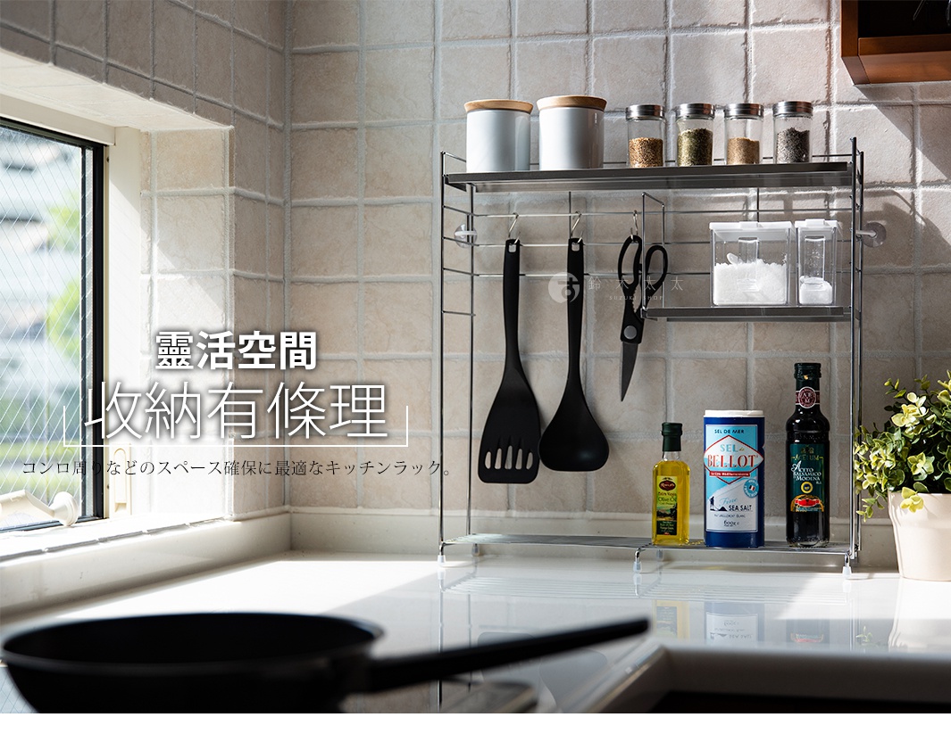 不鏽鋼三層廚房收納架，附三個S型掛勾，架上擺放著鍋鏟、剪刀、調味罐、醬料瓶及綠色盆栽。