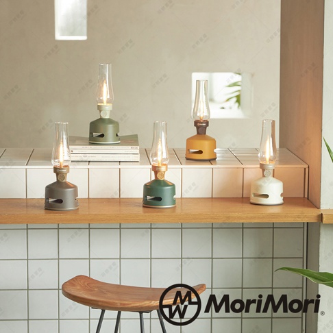 五款不同顏色的 MoriMori LED 煤油燈藍牙音響，包含白色、綠色、灰色、橄欖綠和黃褐色，造型如同復古煤油燈，燈罩為透明玻璃，底部有圓形喇叭孔。